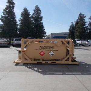 Large tan tanker trailer labeled FLAMMABLE in a parking lot with cars and tall trees in the background.